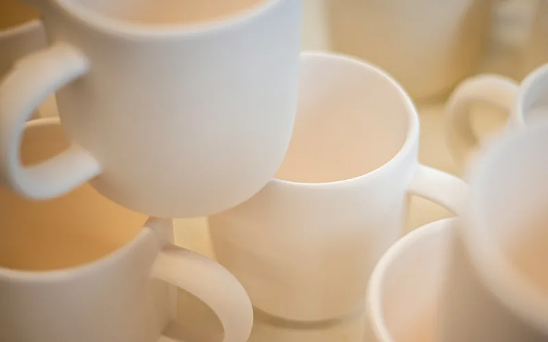 أكواب سيراميك بيضاء، صورة منتج على خلفية بيضاء سادة